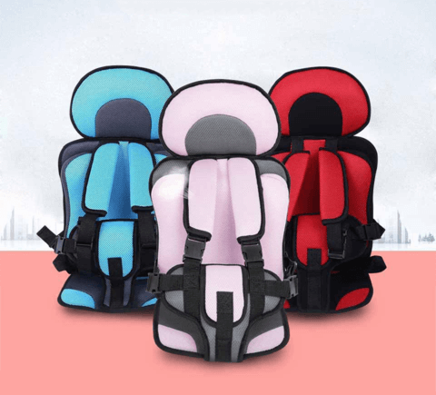 Drei bunte Kindersitze, blau, rosa, rot, mit Sicherheitsgurten auf rotem Hintergrund.